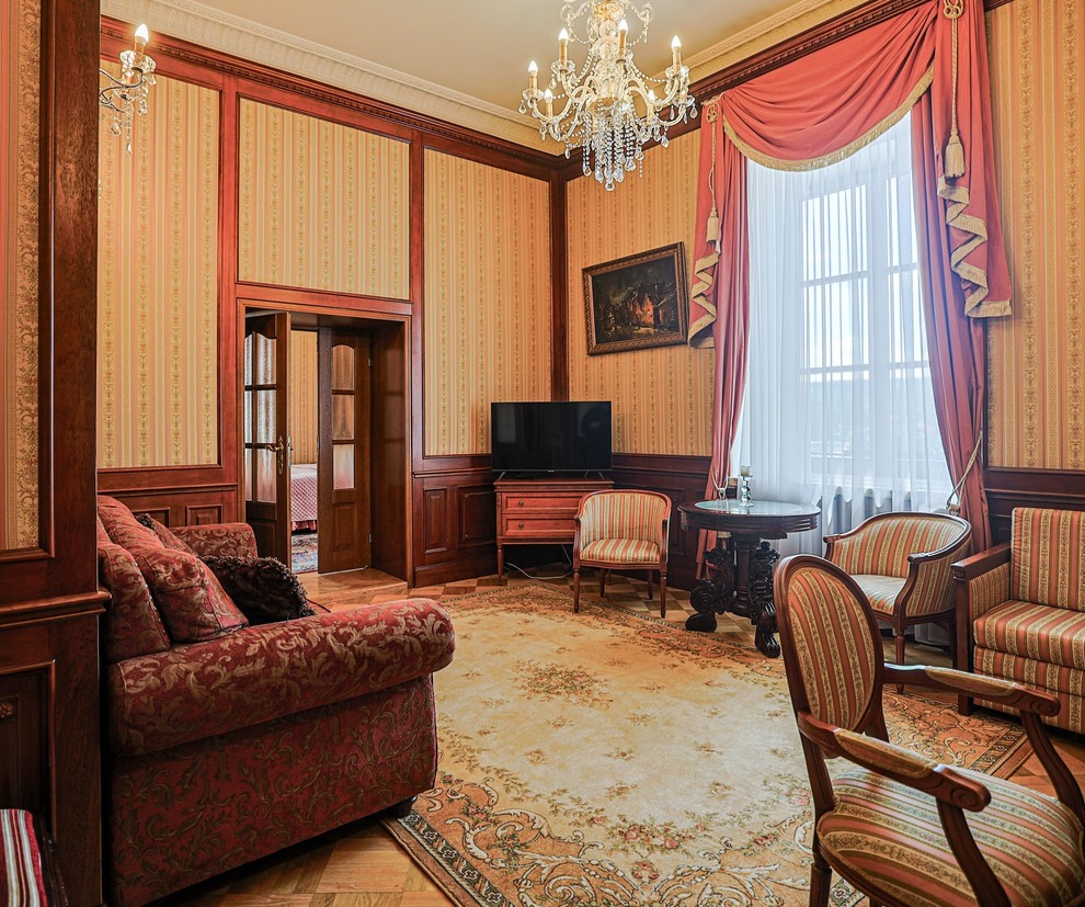 Klasyczny hotelowy salon z kryształowym żyrandolem, aksamitną sofą, pasiastymi fotelami, boazerią i dużym oknem